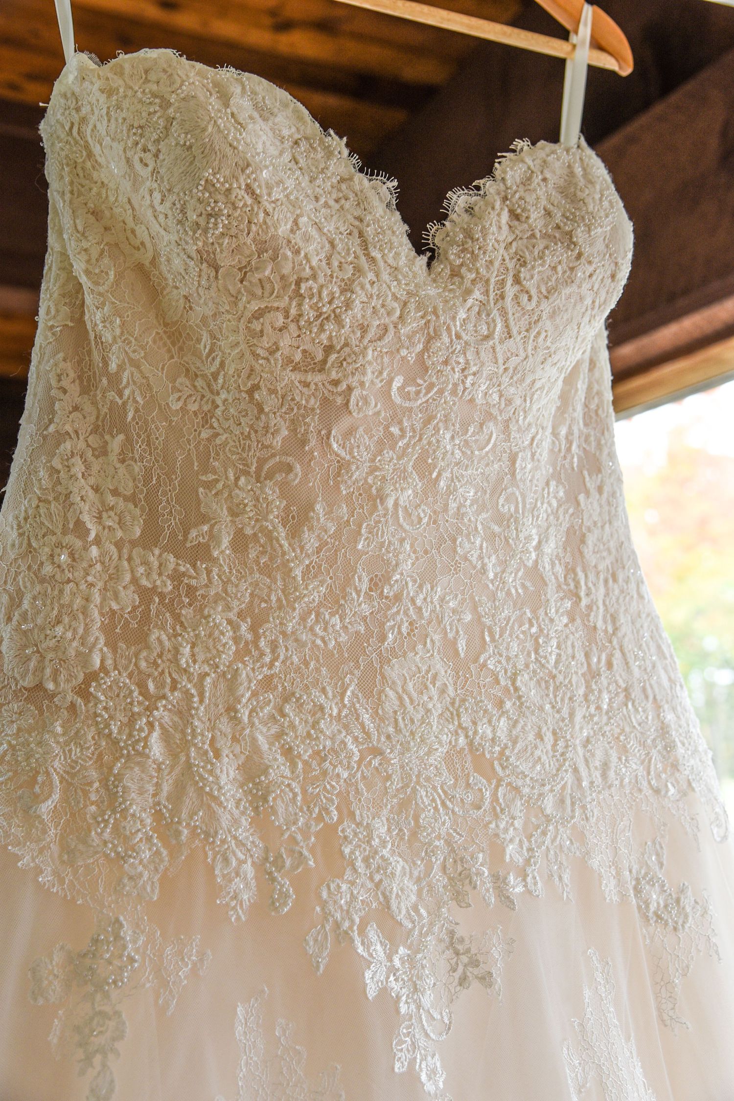 Detailed view of intricate lace bodice on a white strapless wedding gown.