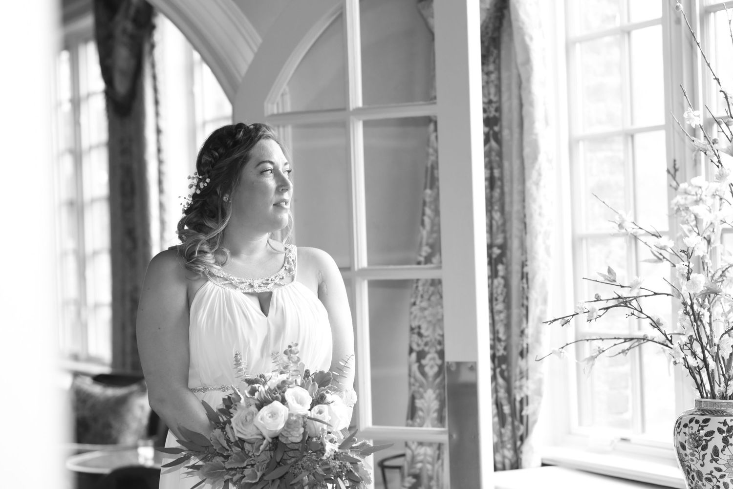 Elegant interior with arched windows and natural light streaming through white curtains.
