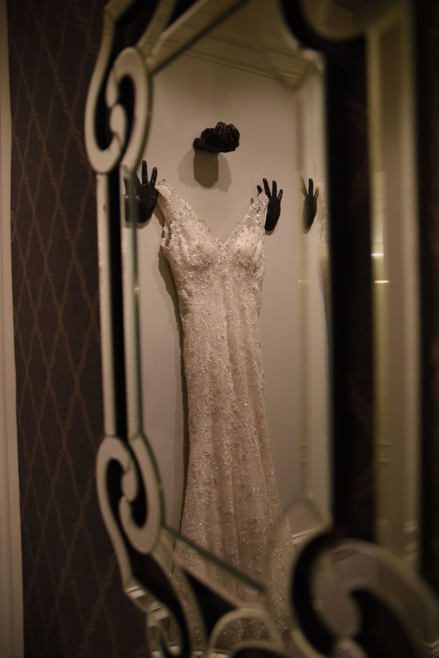 Multiple views of an elegant white lace wedding dress hanging in a dressing room.
