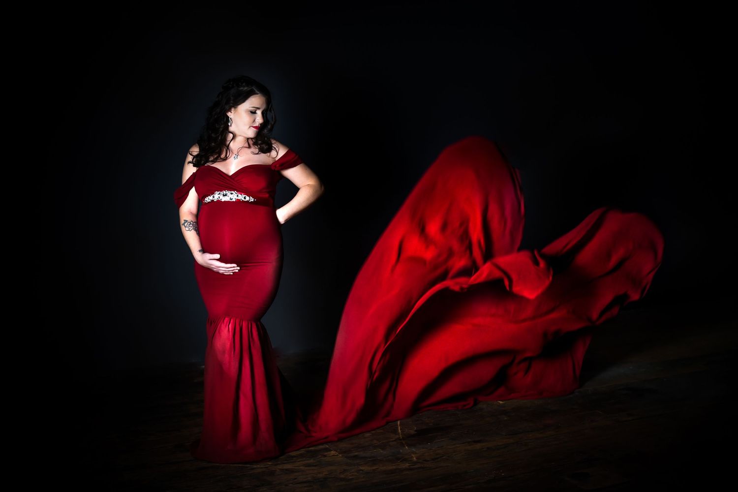 A dramatic series of photos showing a flowing red dress against a dark background creating an ethereal effect.