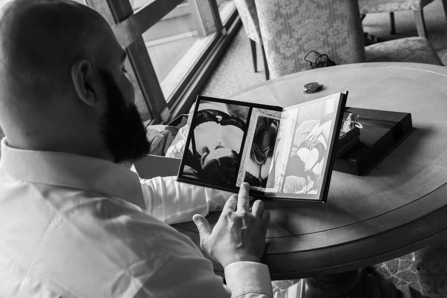 Black and white image of people looking at phones during wedding preparations.