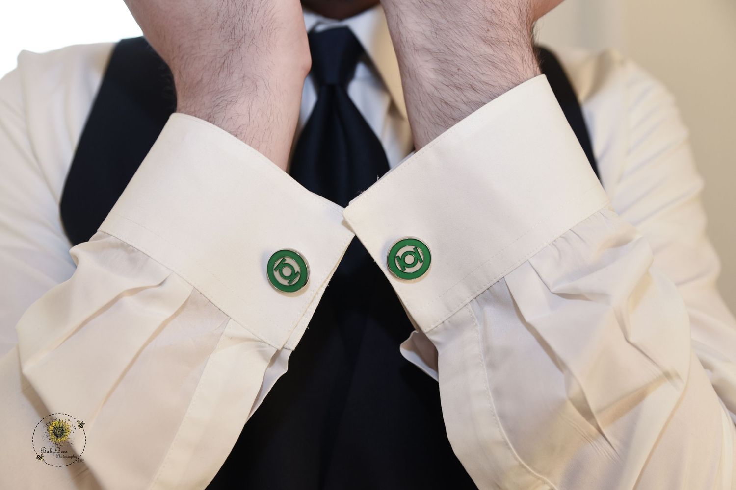 Close-up of white dress shirt cuffs with emerald green cufflinks.