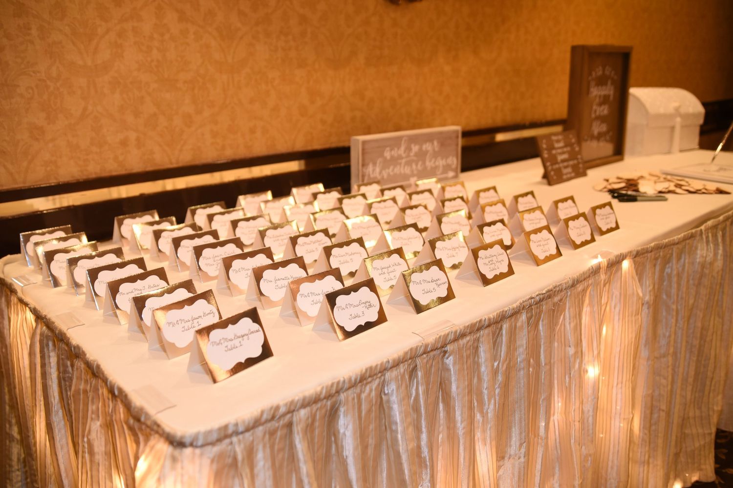 Long table setup with place cards and wedding favors arranged in neat rows.