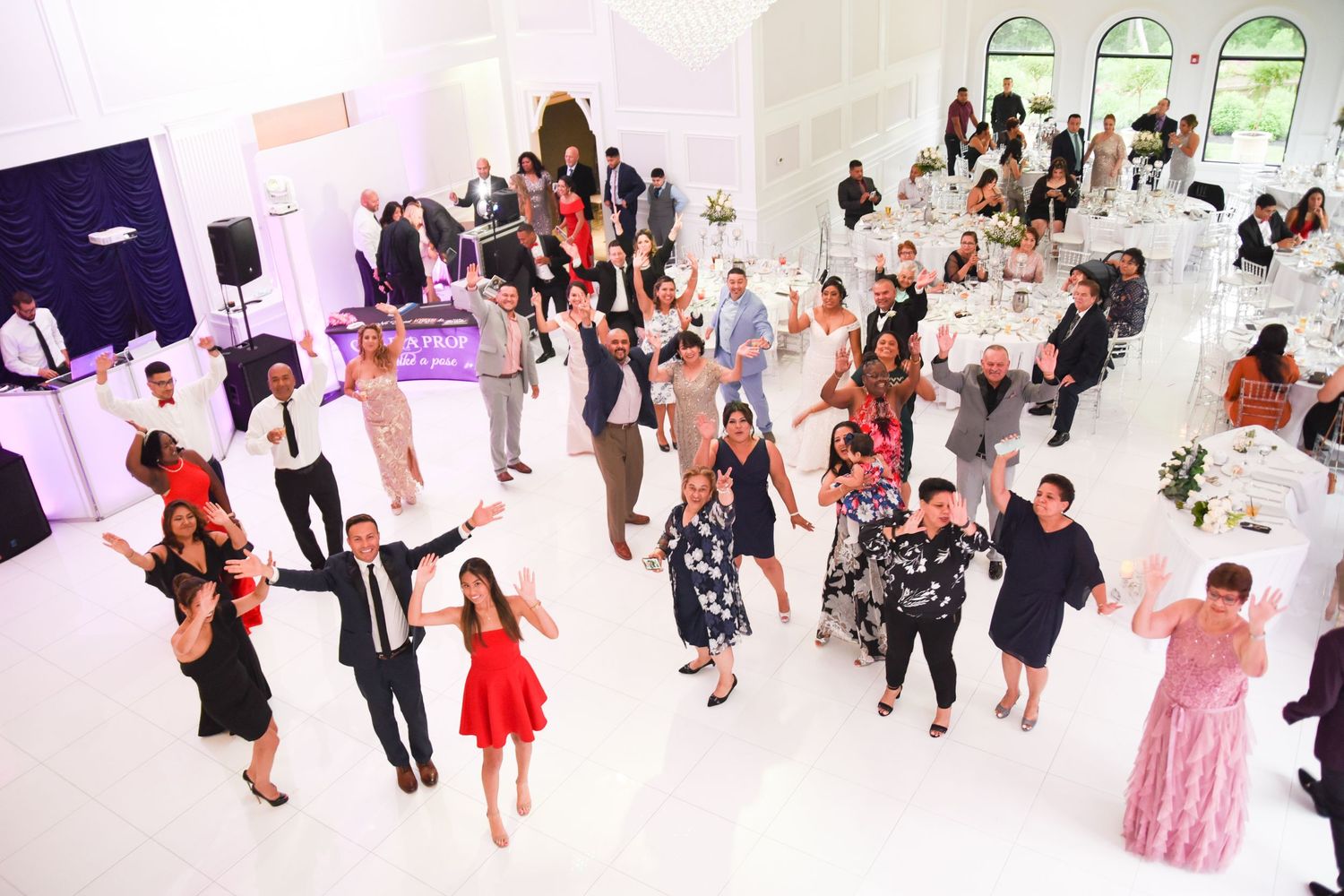Wedding reception dance floor filled with guests celebrating and dancing together.
