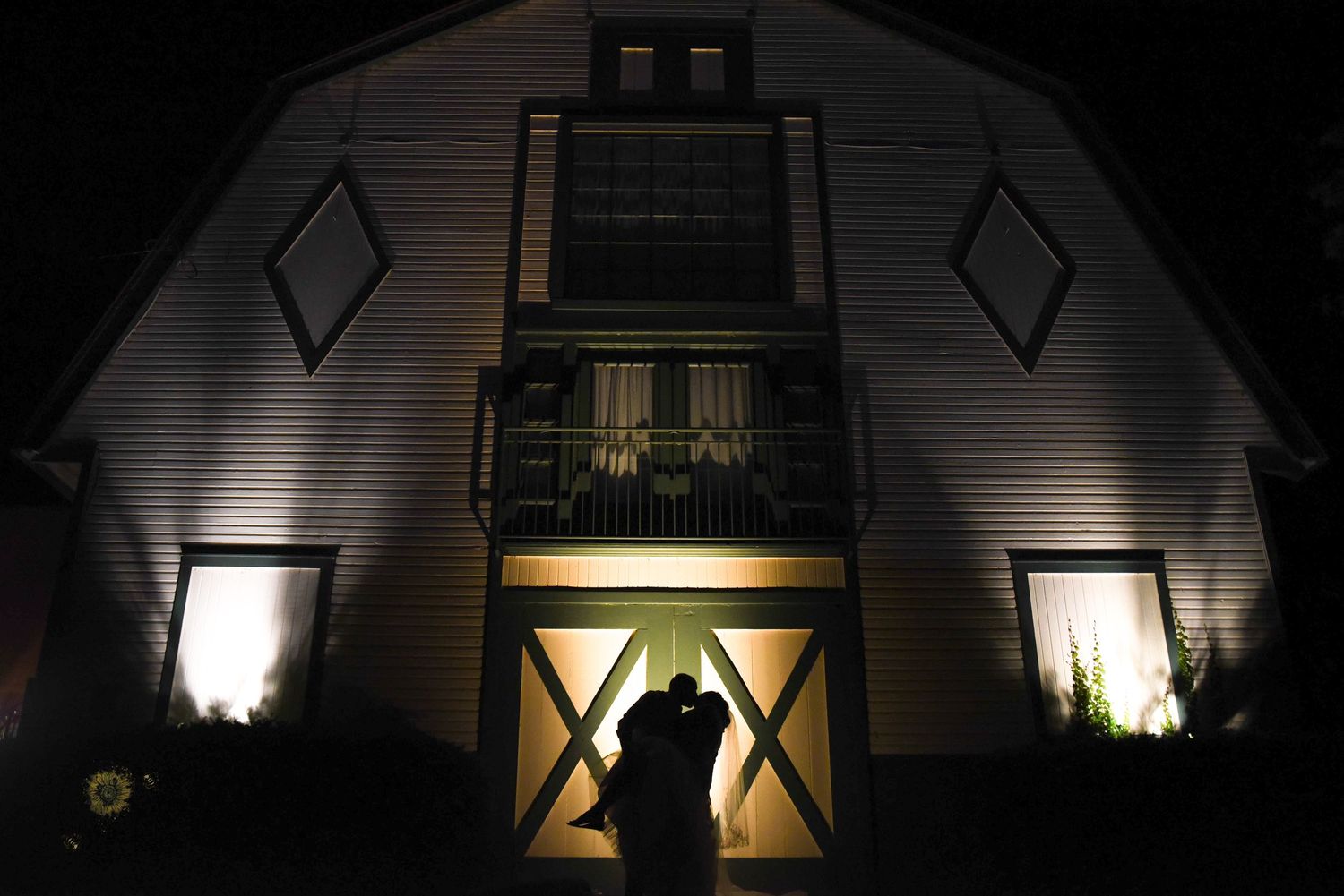 Exterior of building illuminated at night with dramatic lighting and architectural details.