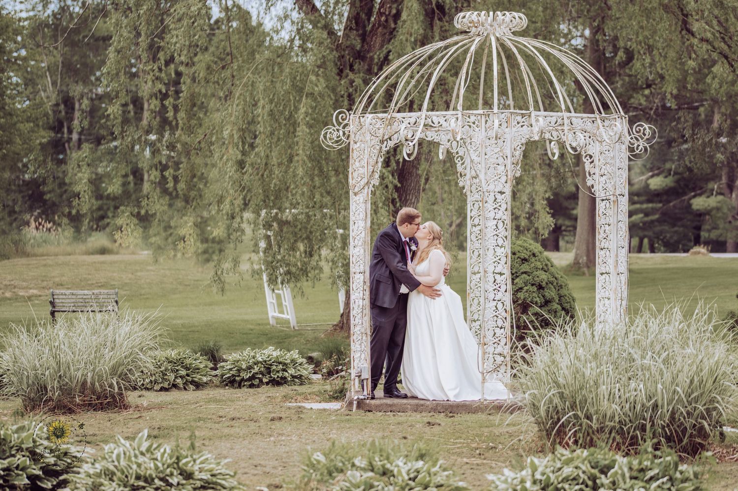 Beautiful outdoor wedding ceremony setup with white gazebo and floral arrangements.