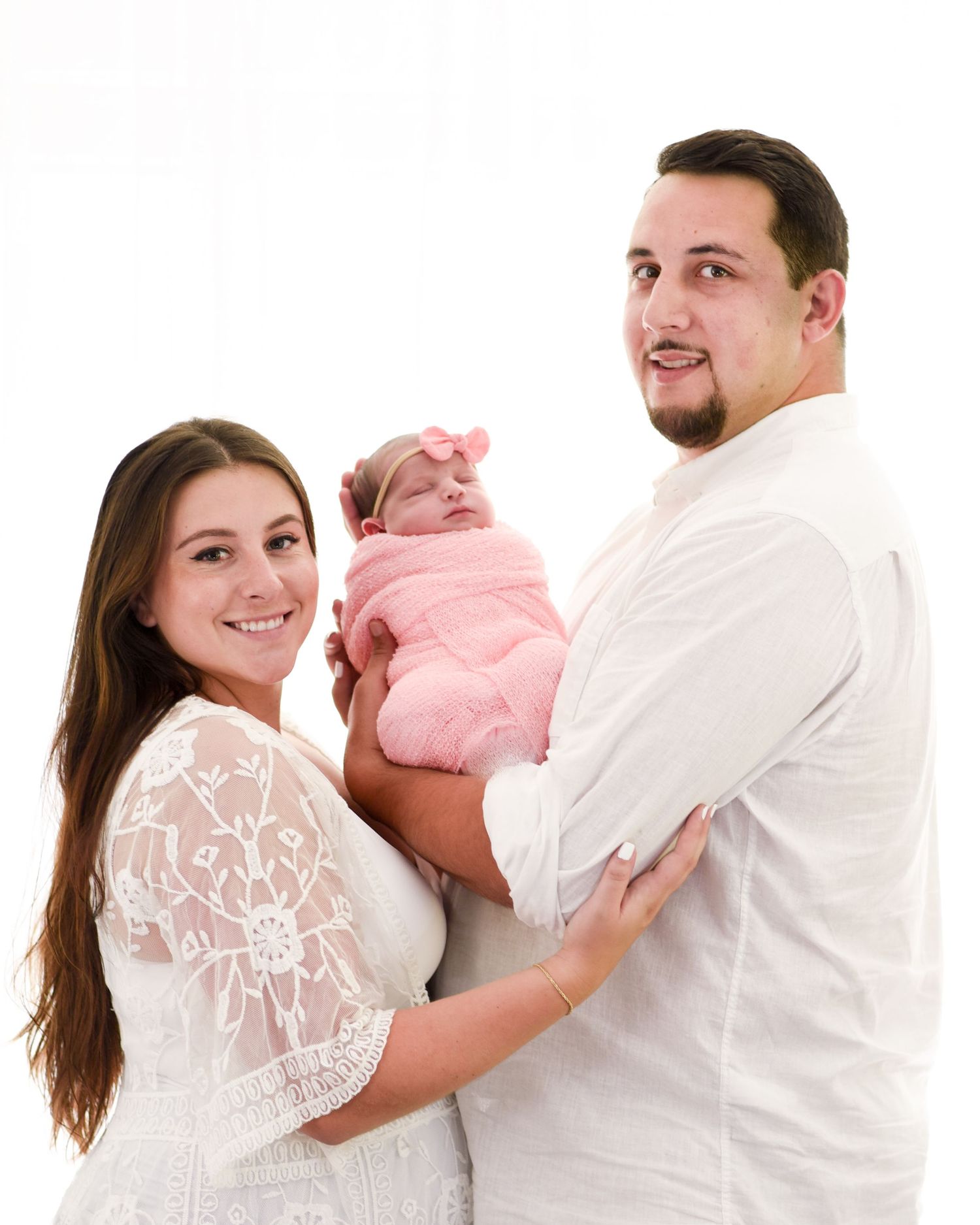 A series of progressive images showing a parent cradling and interacting with a baby in white and pink clothing.