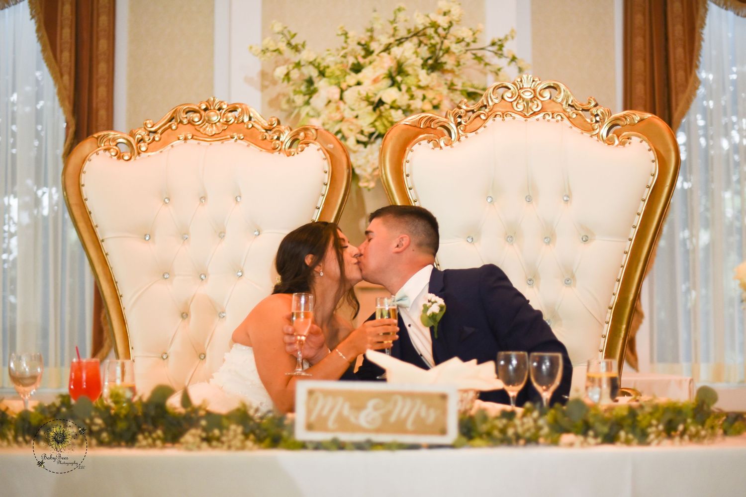 Elegant reception setup with ornate cream-colored chairs and floral arrangements.