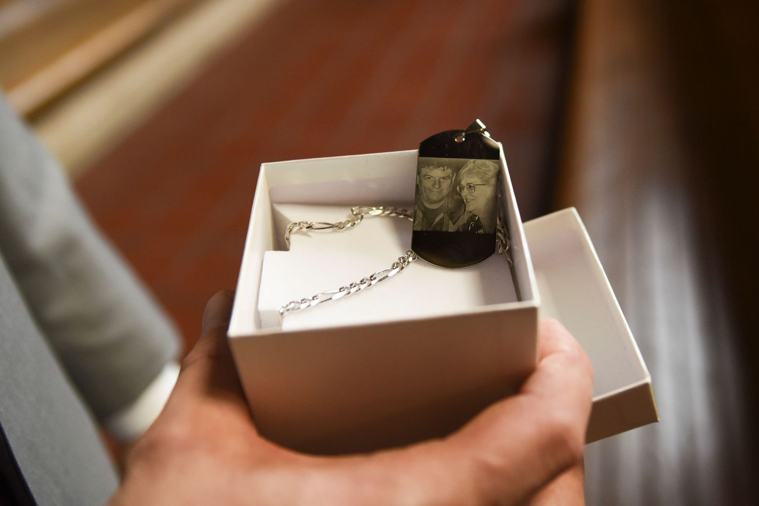 Wedding invitation and details being carefully removed from elegant white box.