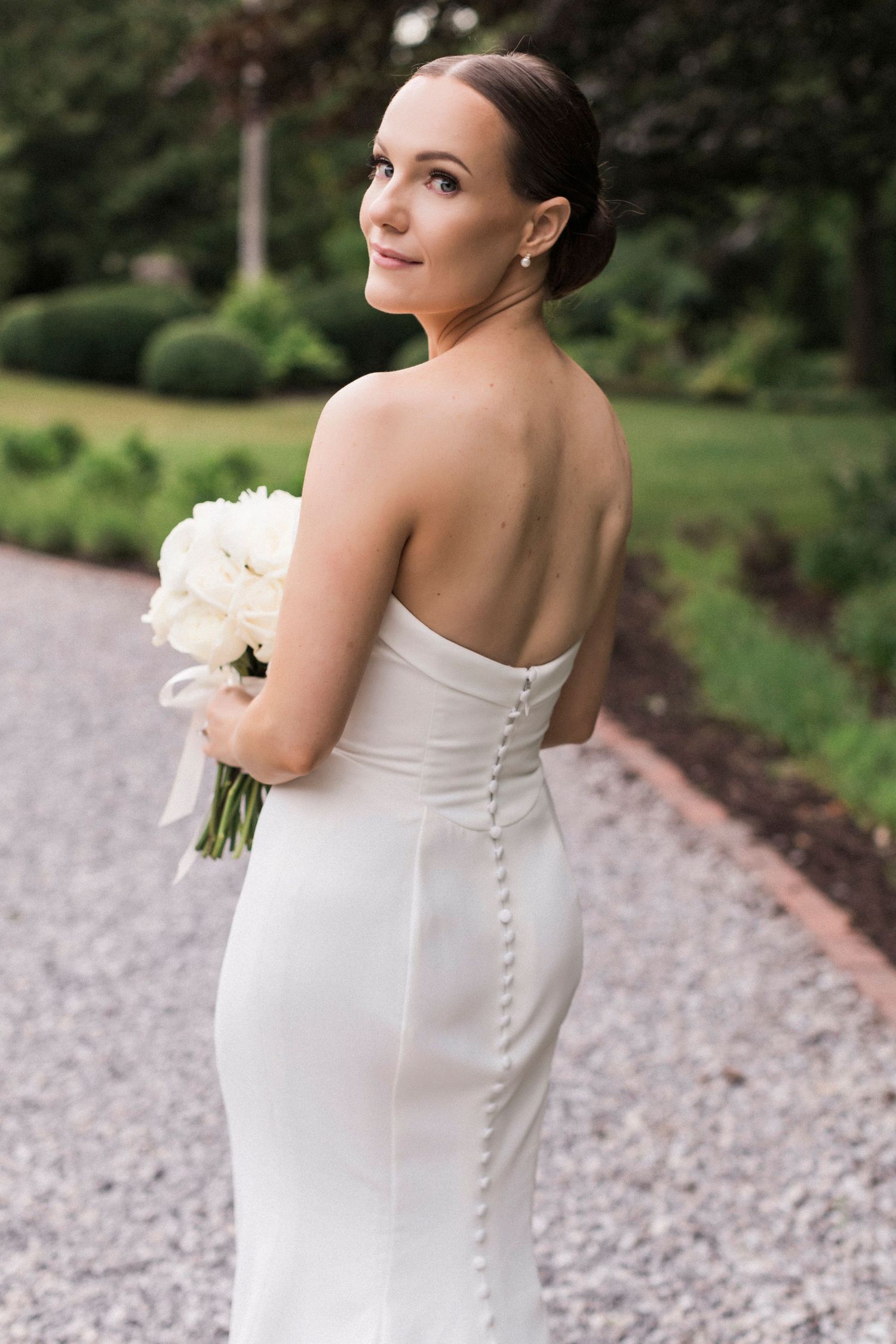 Close-up details of an elegant strapless wedding gown with button details down the back.