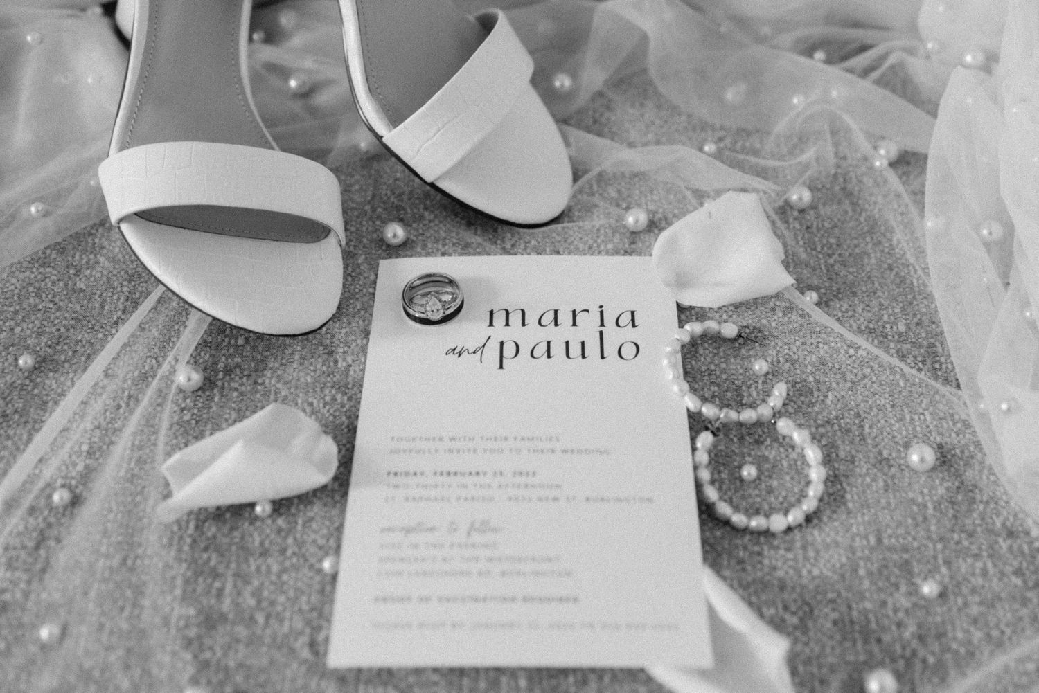 Wedding details with white shoes, invitation and delicate accessories.
