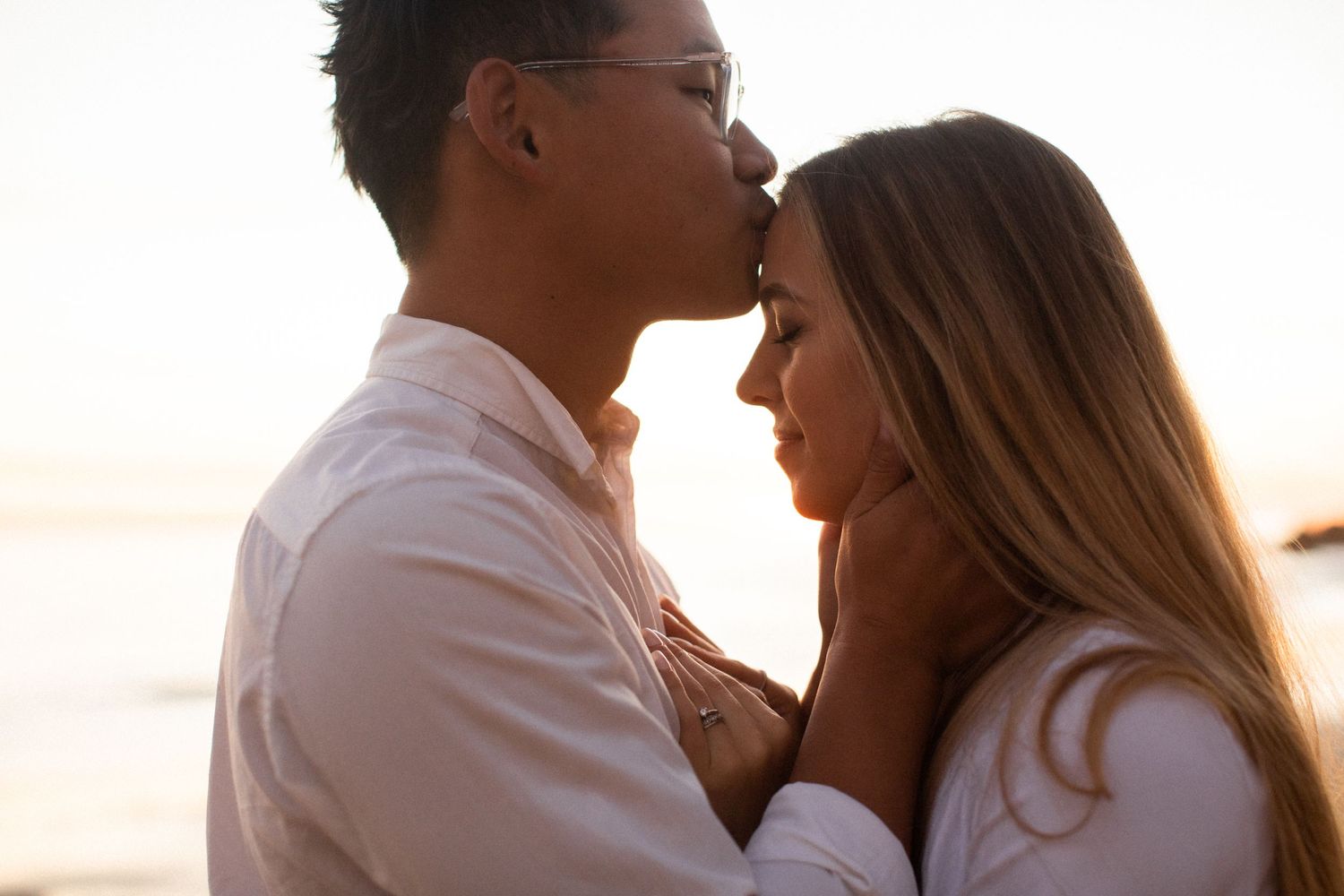 Couple sharing an intimate moment at sunset on the beach.