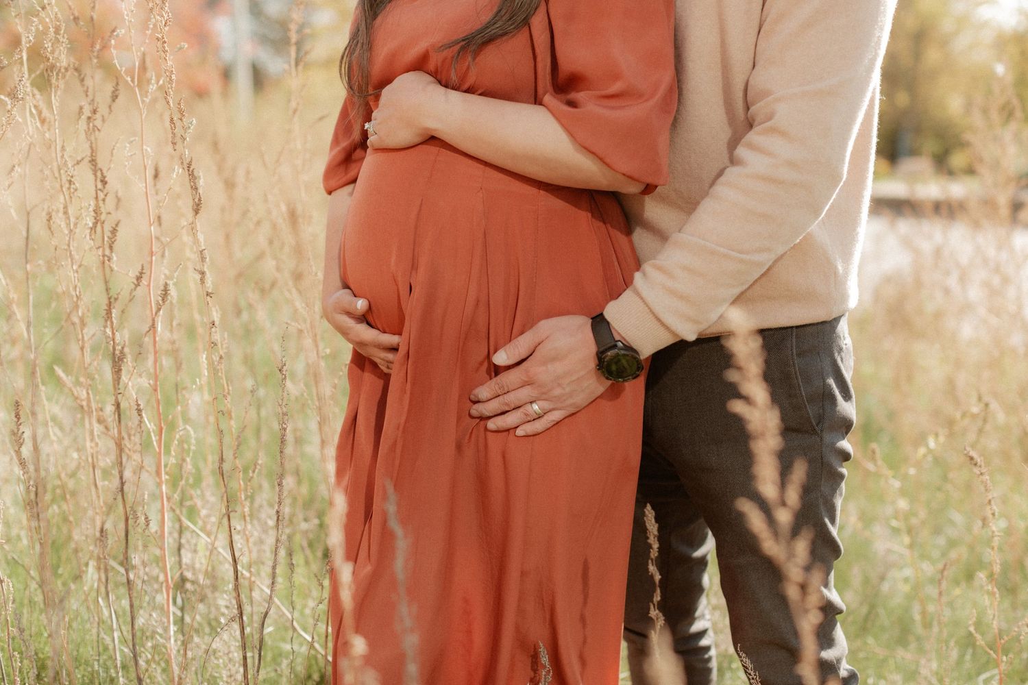 Side view of a couple sharing an intimate moment during their maternity shoot in nature.