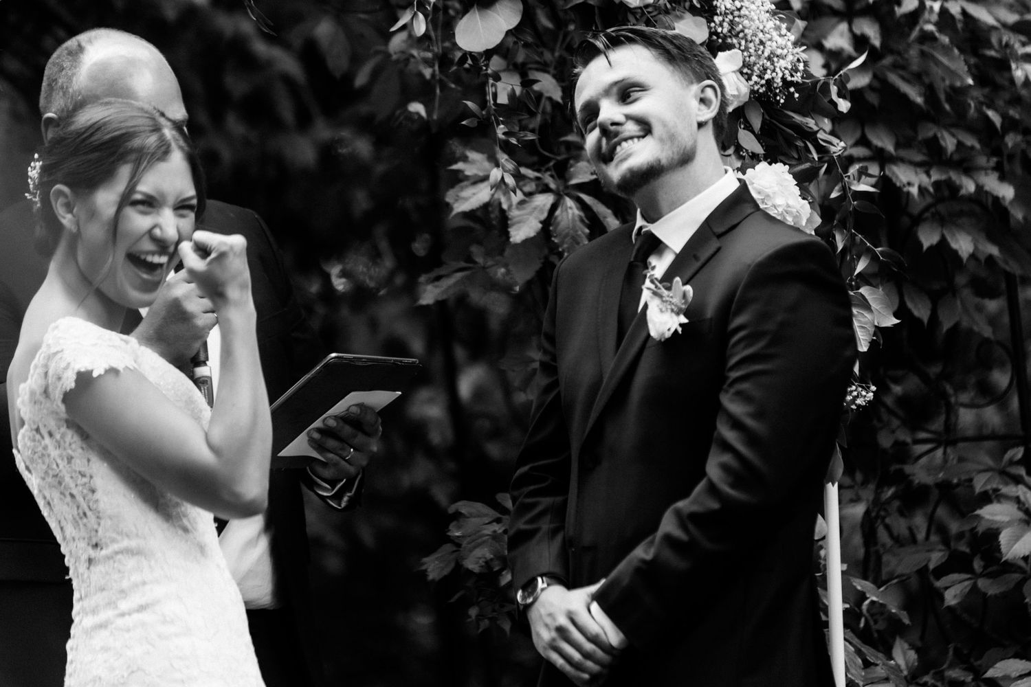 Black and white capture of an emotional wedding ceremony moment in a garden setting.