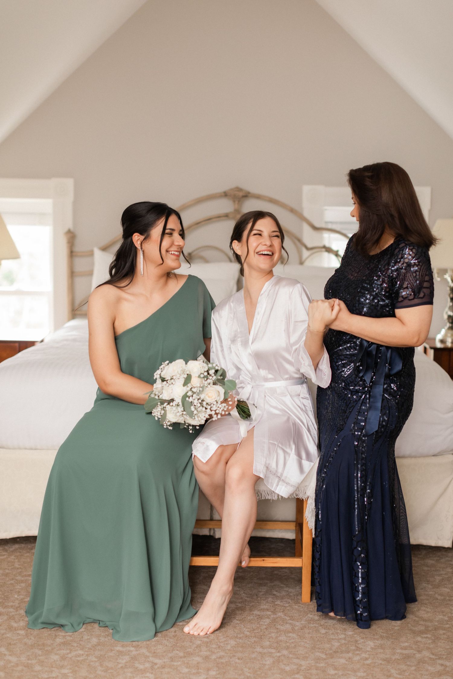 Wedding party sharing joyful moment together in bright bedroom setting.