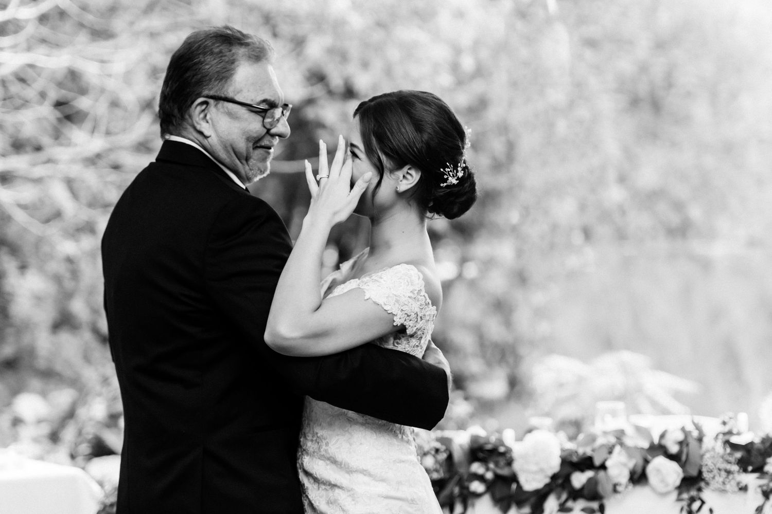 Black and white emotional moment captured during outdoor wedding ceremony.
