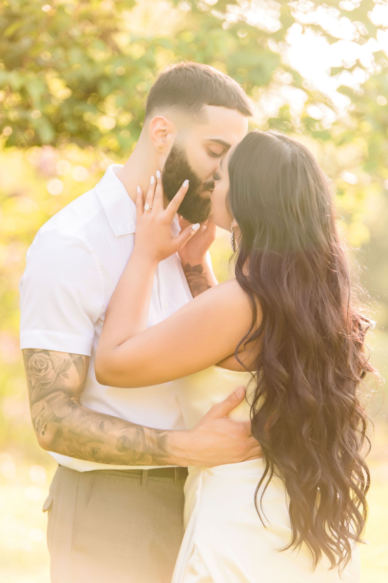 Romantic sunset engagement photo with couple sharing intimate moment.