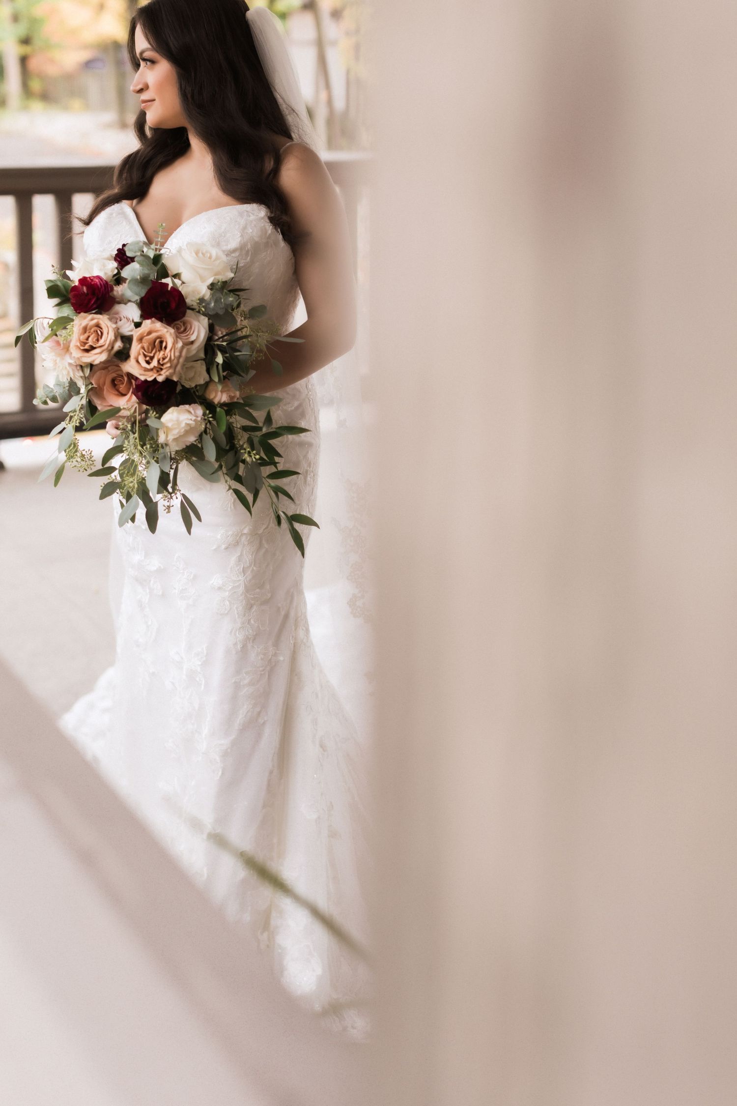 Elegant white lace wedding dress with a sweetheart neckline and floral bouquet.