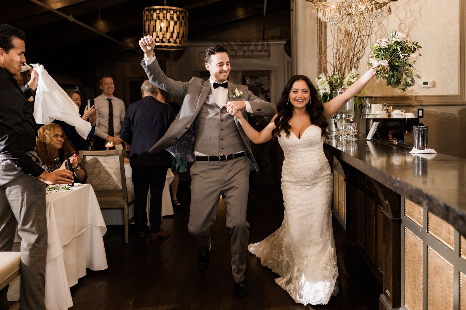 Wedding celebration with couple dancing joyfully in reception venue.