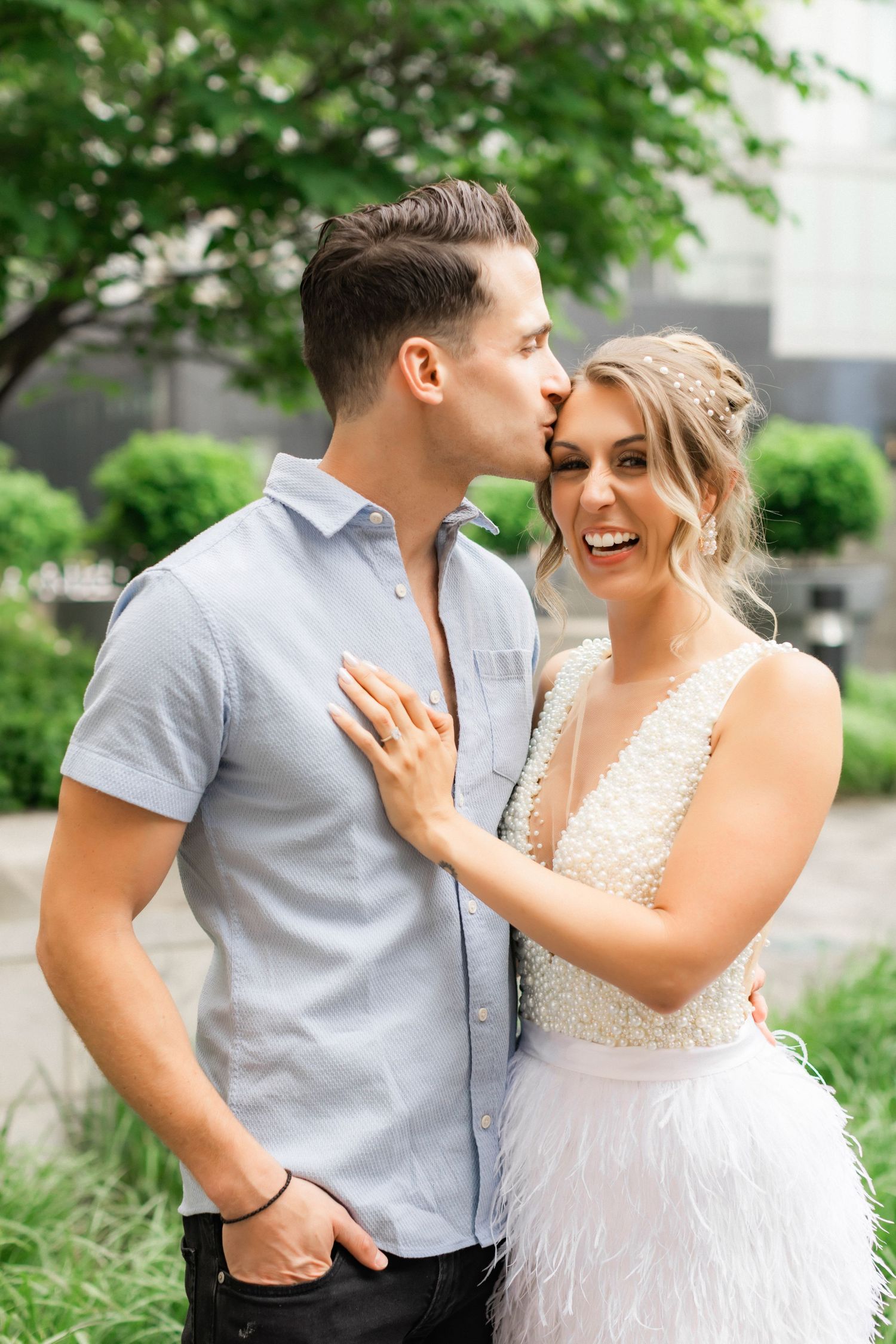 A romantic couple sharing an intimate moment outdoors in casual and formal attire.