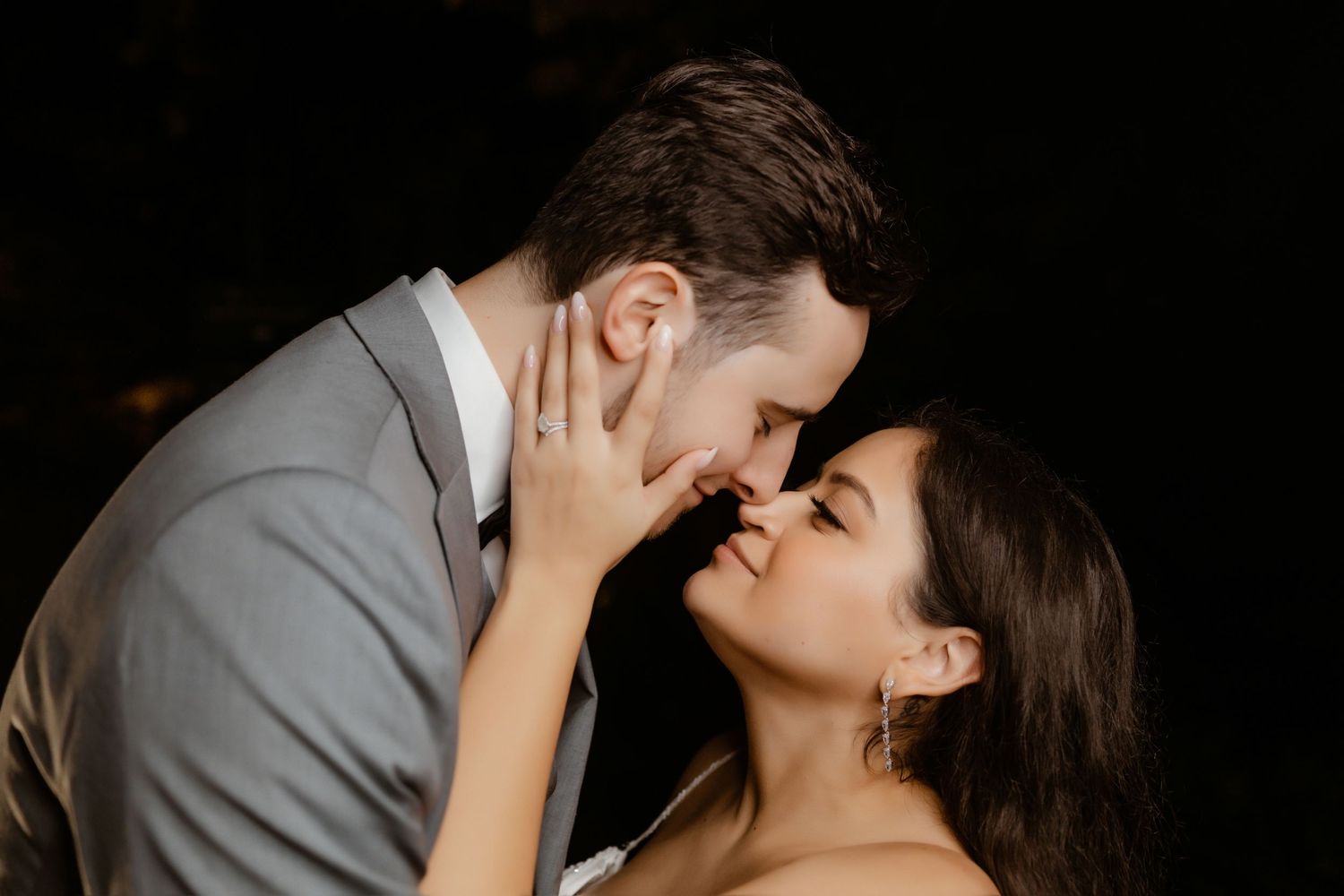 Close-up portrait of a couple in wedding attire sharing a romantic moment.