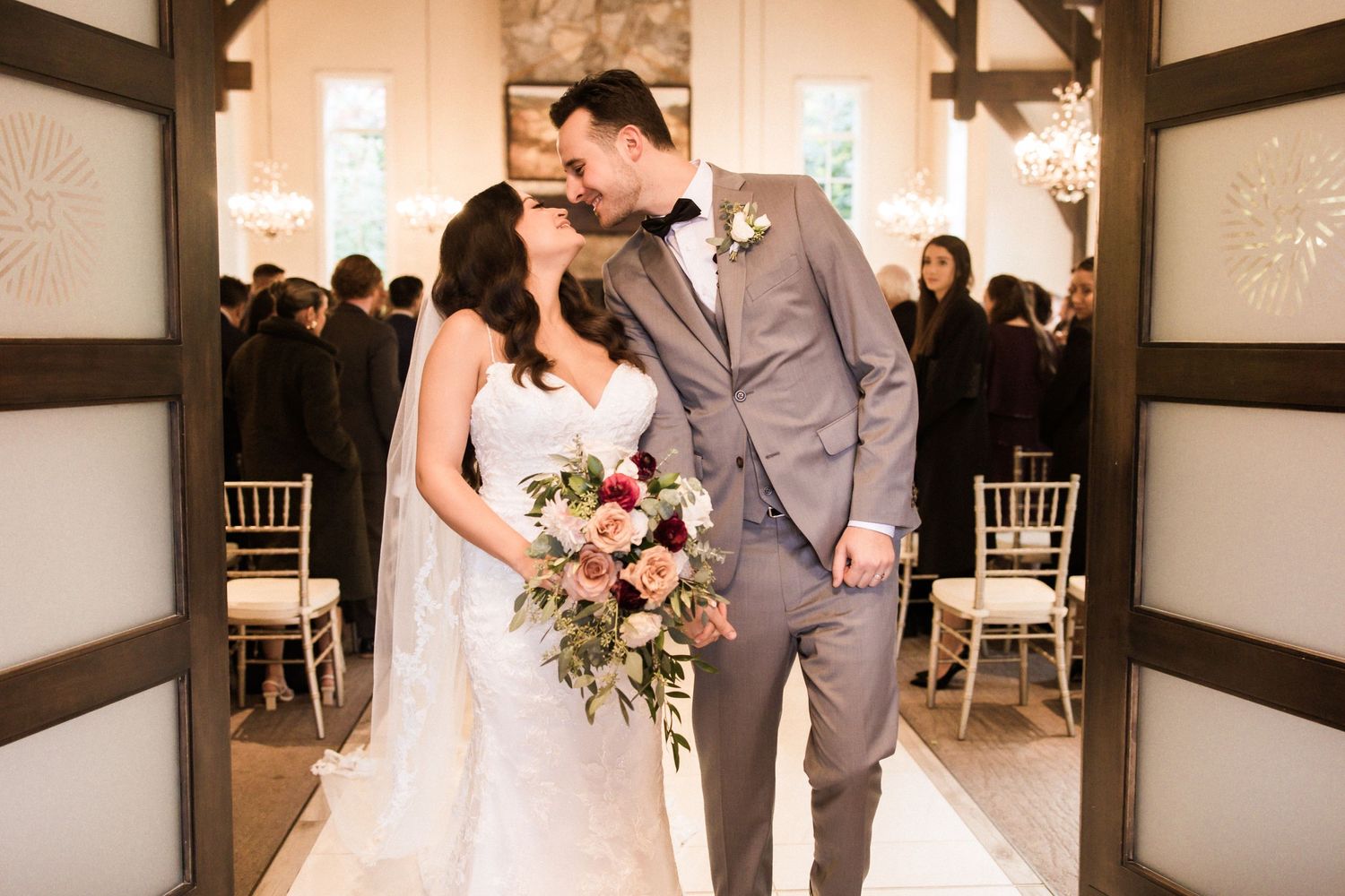 Intimate wedding portrait in rustic venue with exposed wooden beams and natural lighting.