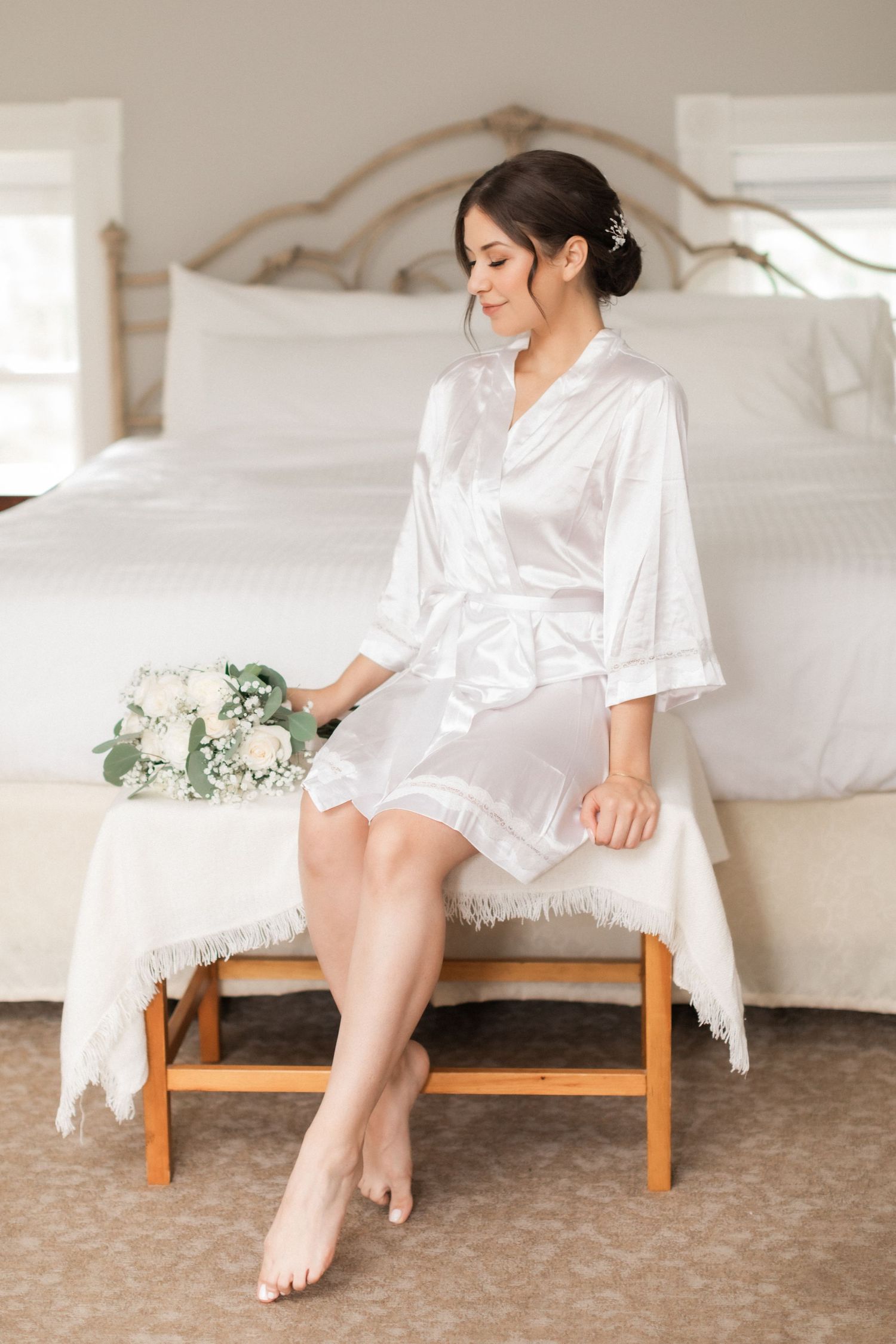 Elegant bridal morning preparation scene with silk robe and floral bouquet.