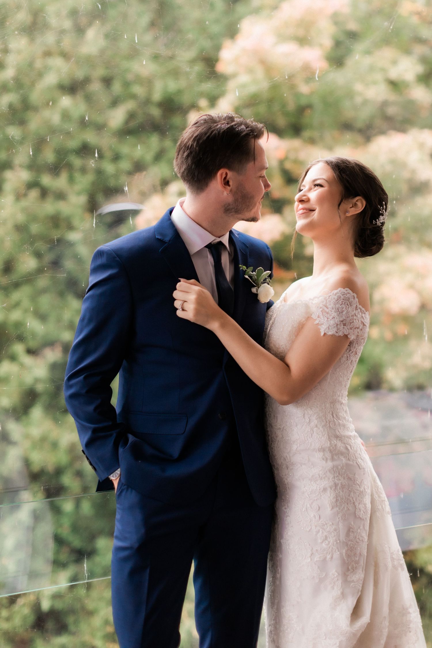 Happy couple embracing and laughing during outdoor wedding photoshoot.