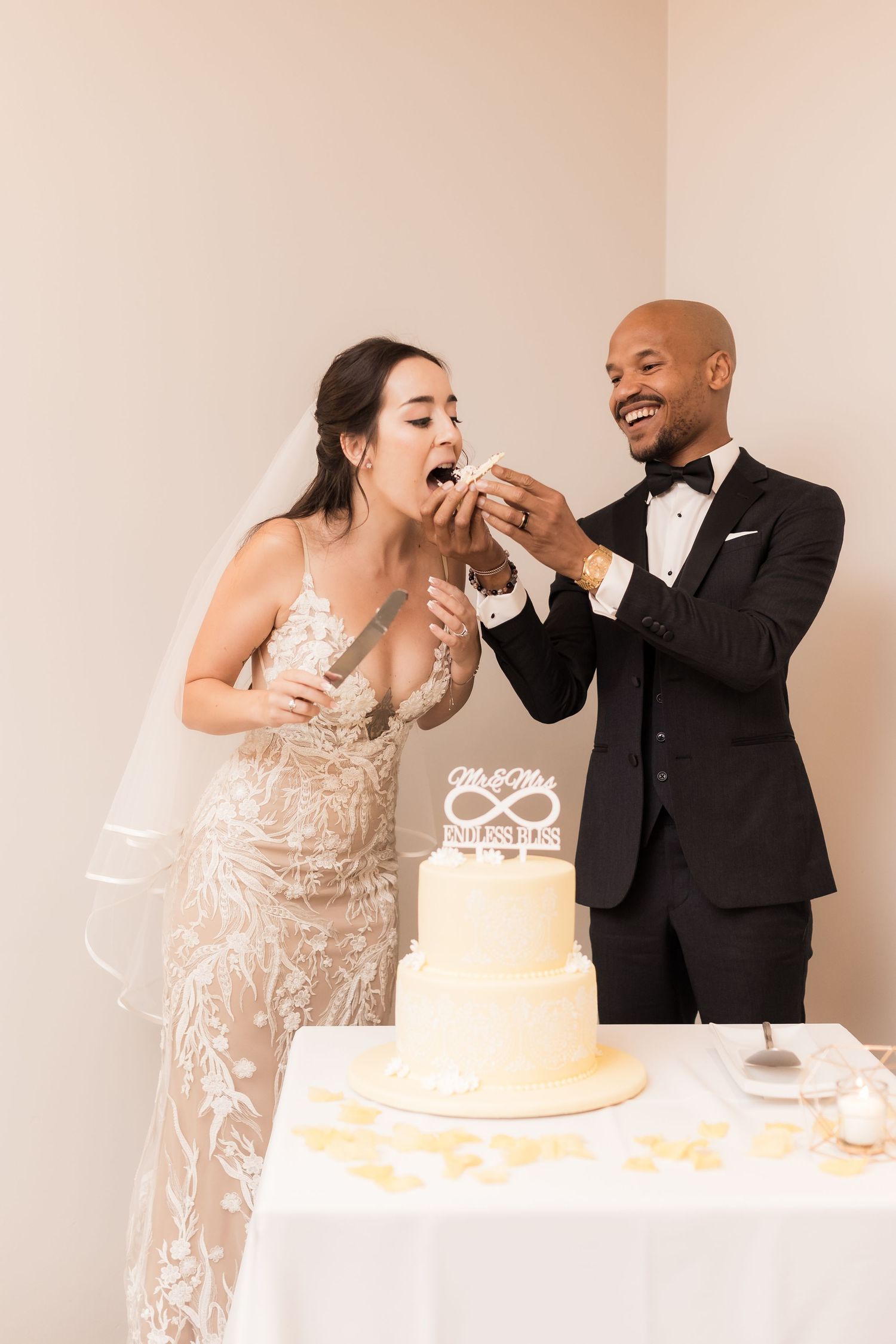Playful cake-feeding moment shared between the newlyweds at their reception.