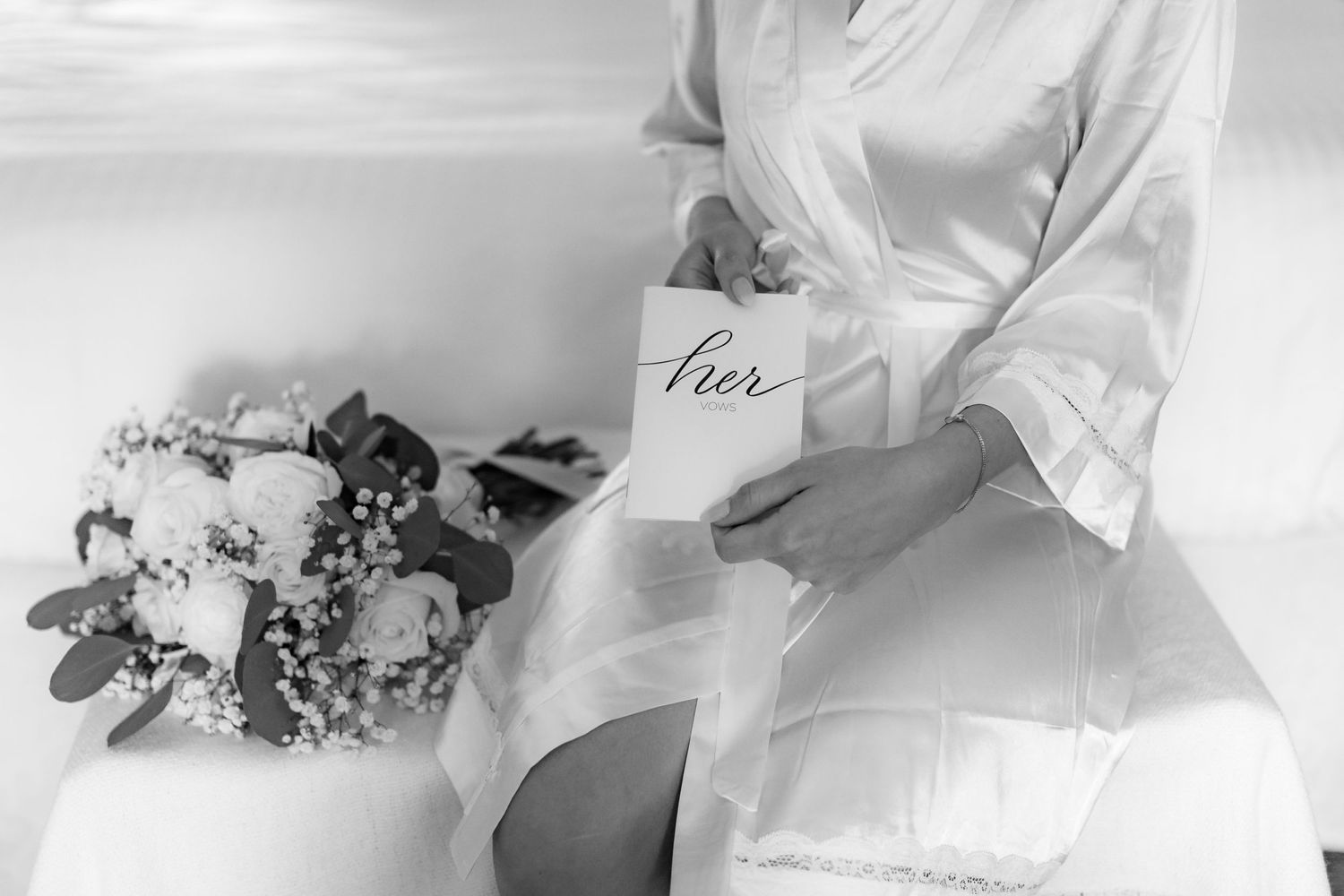 Black and white photo of bridal robe and wedding details.