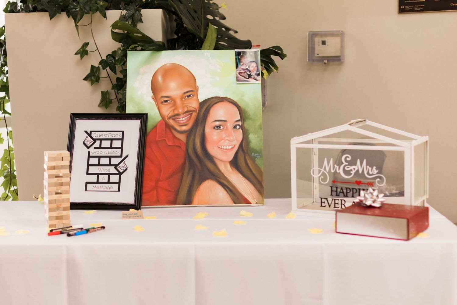 Wedding reception table display with framed artwork and clear acrylic display box.