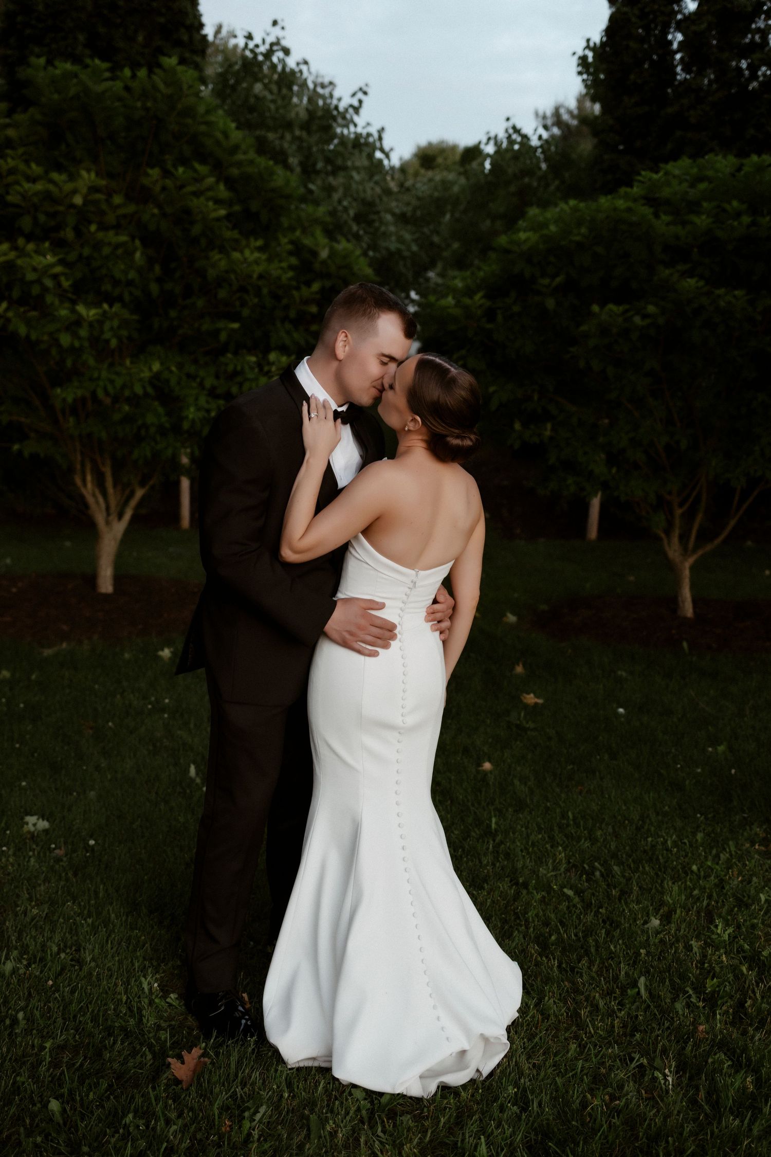 A couple shares a romantic moment in a lush garden setting during their wedding photo session.