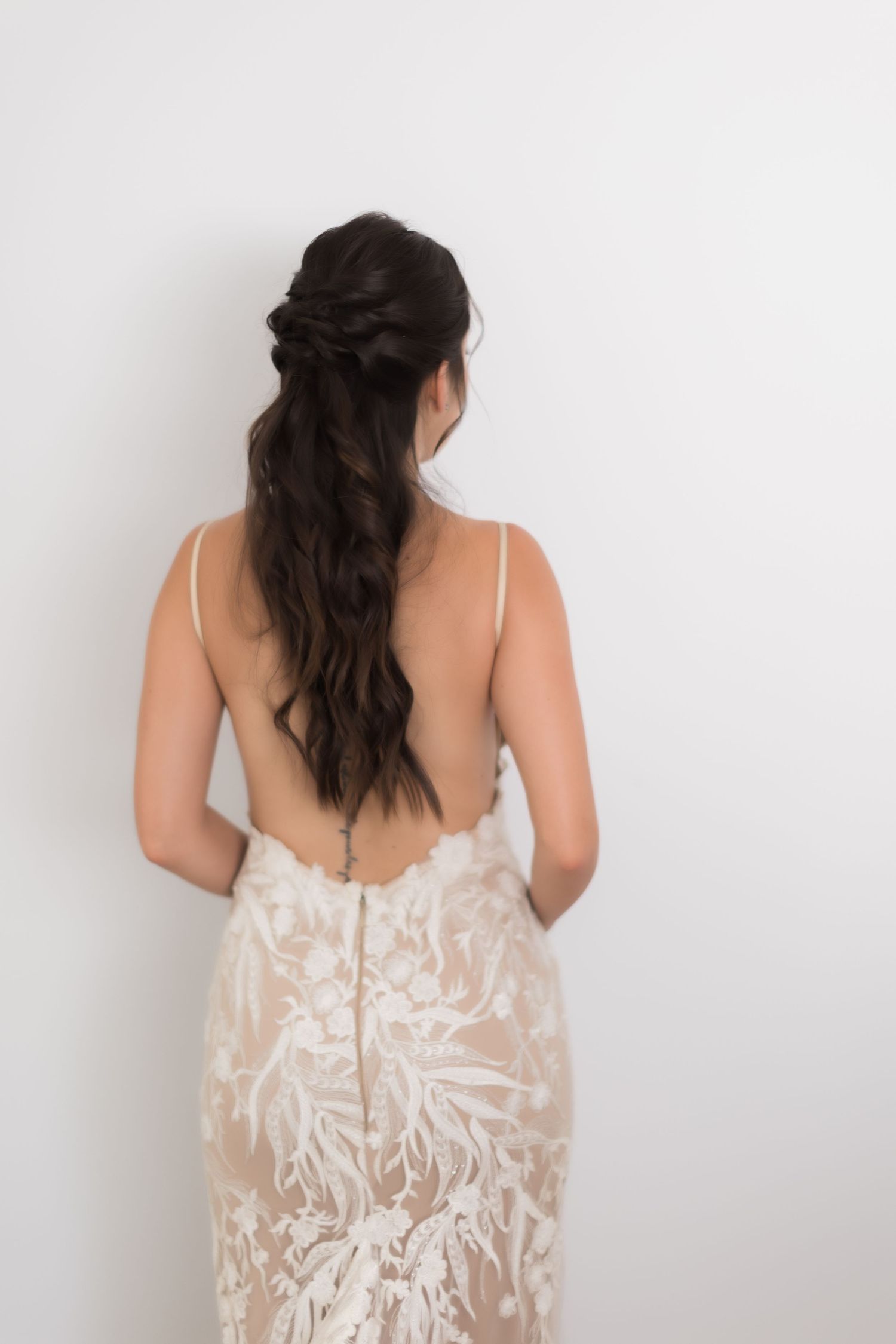 Back view of intricate lace wedding dress showing open back design.