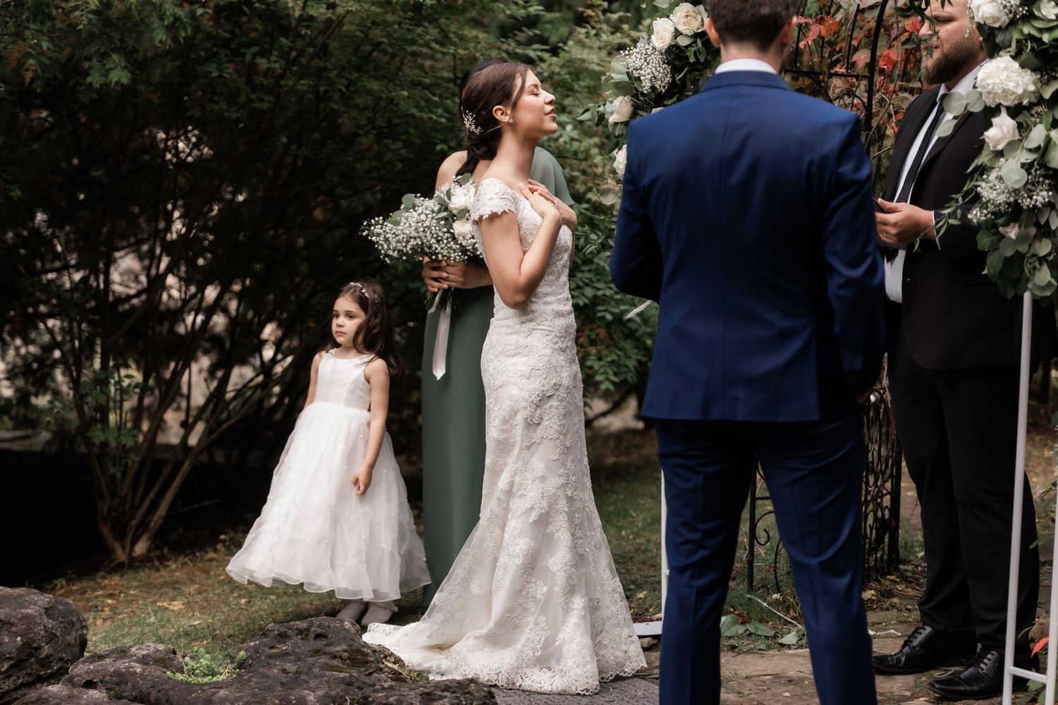 Joyful candid moment of bride laughing during outdoor garden wedding celebration.