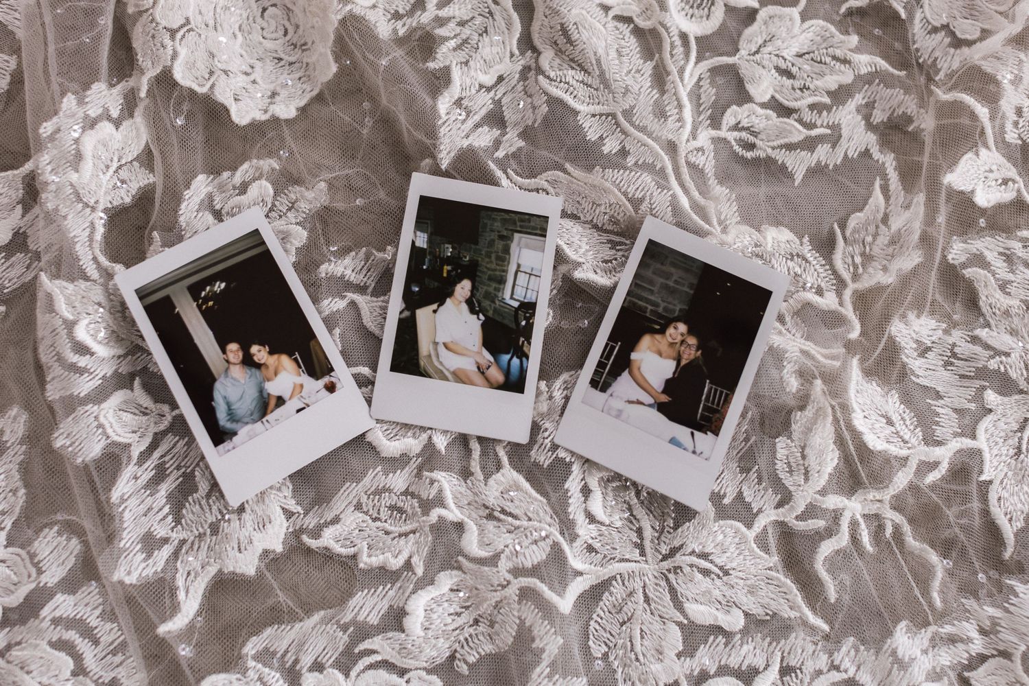 Polaroid wedding photos displayed on a floral lace fabric background.