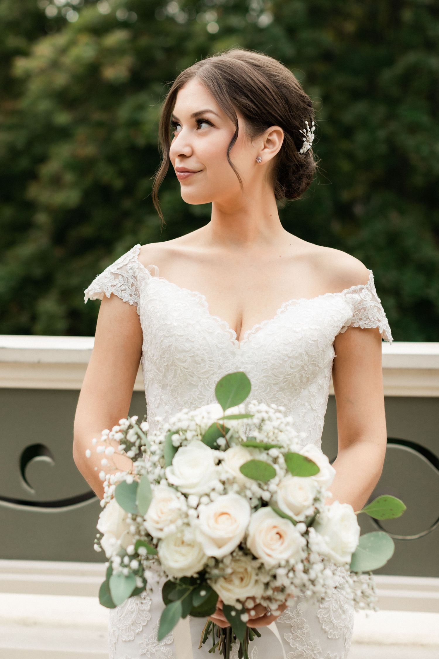 Bridal portrait featuring off-shoulder lace gown and classic white rose bouquet.