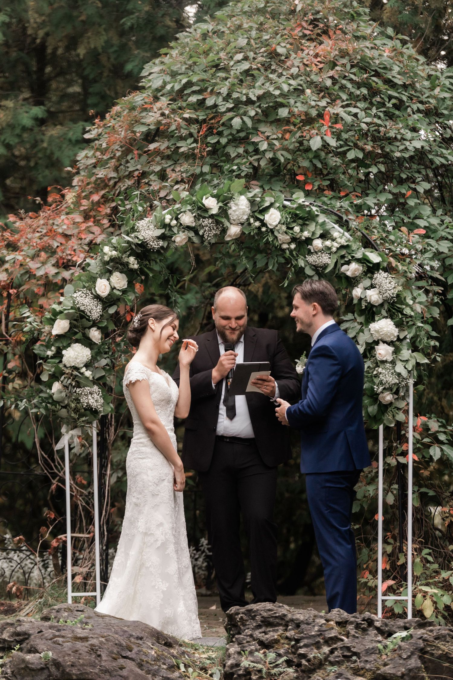 Wedding party walking down garden path decorated with white balloons and floral arrangements.