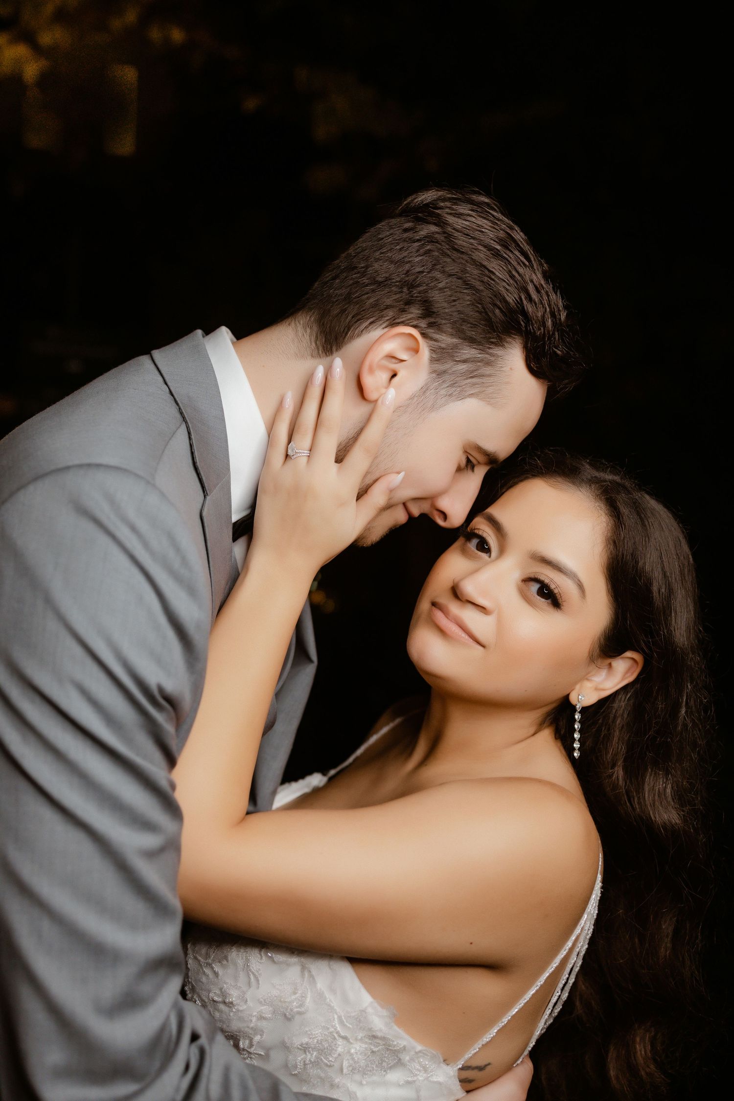 Intimate portrait of a couple in wedding attire sharing a tender moment.