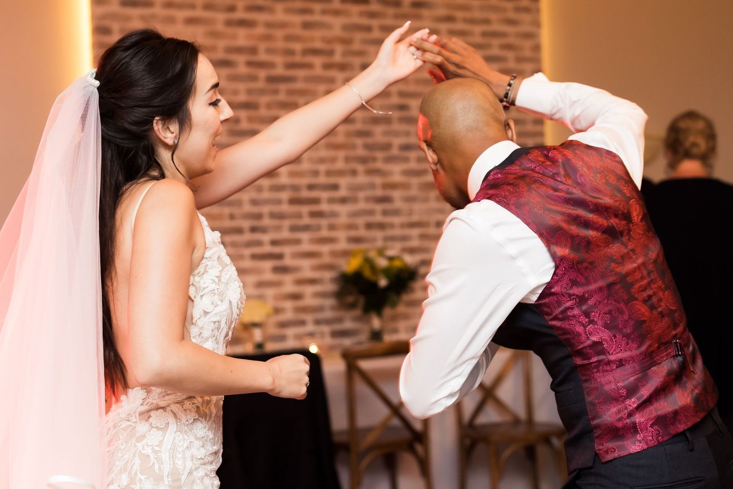 A playful dancing moment between newlyweds during their wedding reception.