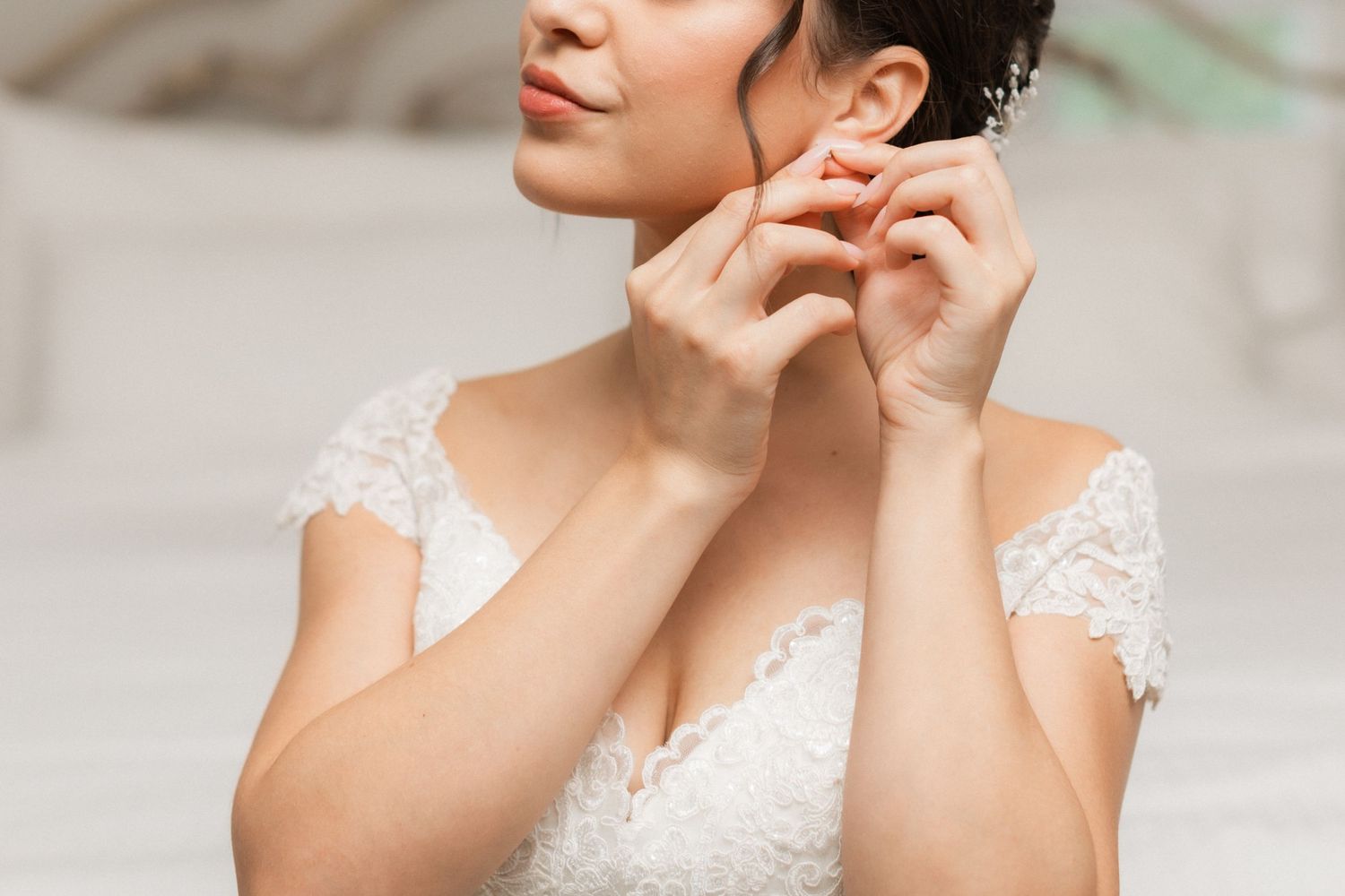 Close-up shot of delicate lace details and jewelry preparations on wedding day.
