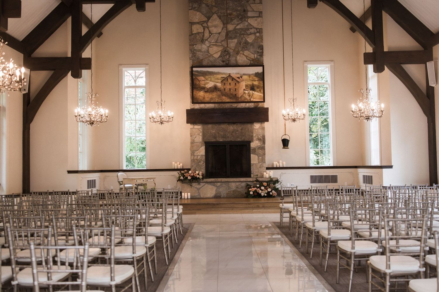 Modern chapel with high ceilings, stone fireplace and symmetrical rows of chairs for ceremony seating.