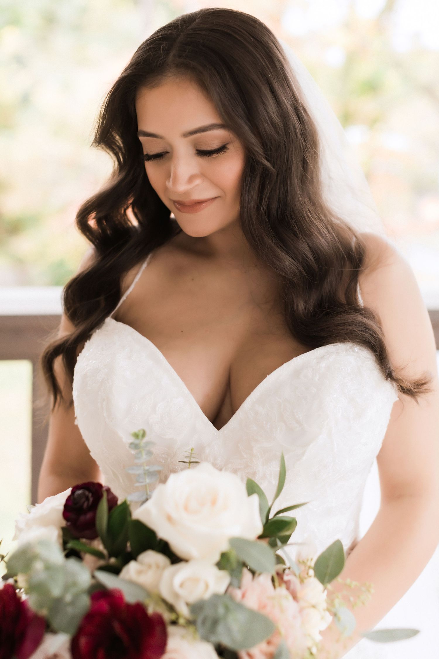 Bridal portrait featuring elegant white strapless gown and romantic bouquet.
