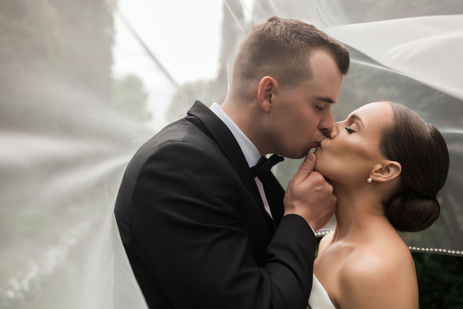 Bride and groom share tender intimate kisses in sequence of romantic black and white wedding portraits.