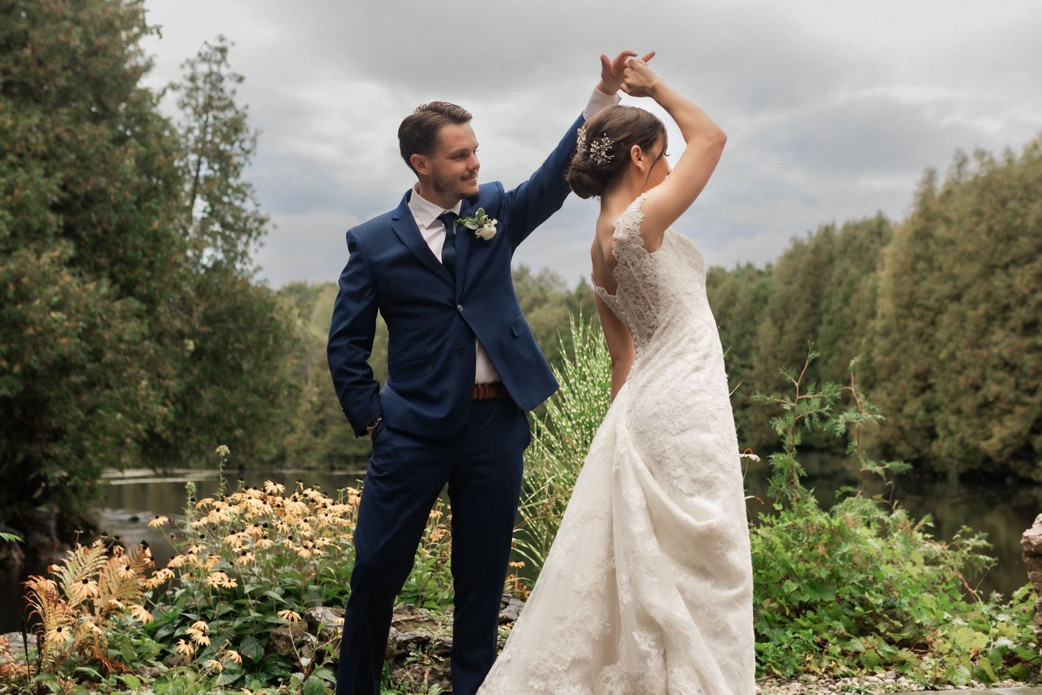 Playful wedding dance moment captured in garden setting with autumn foliage.