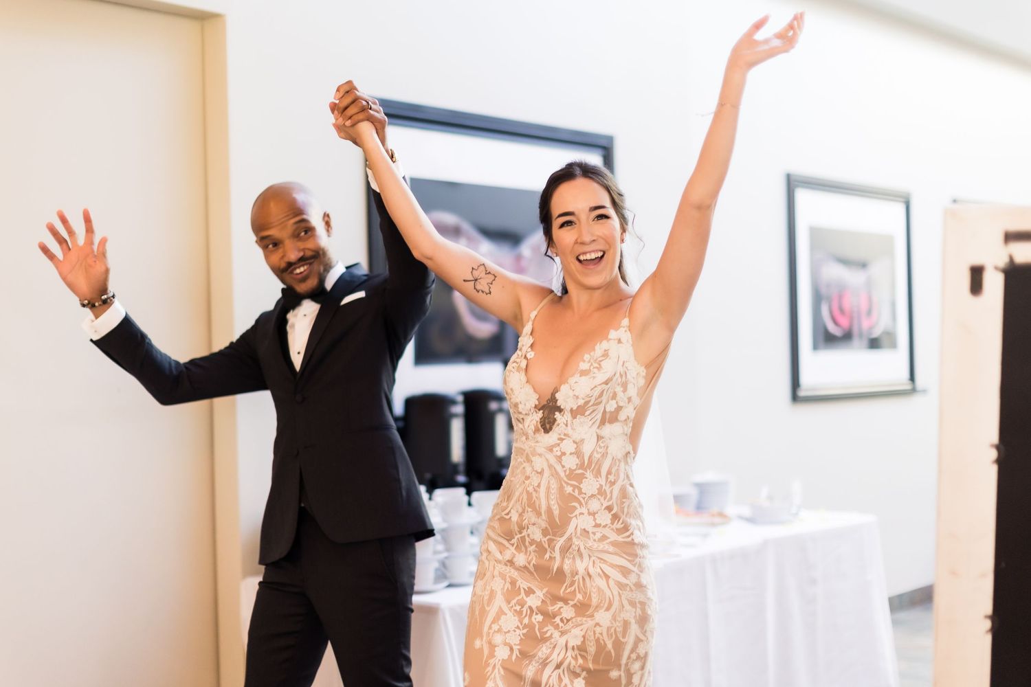 A joyful wedding celebration moment captured with dancing and raised arms.