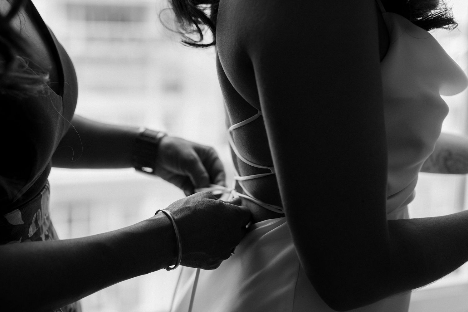 Close-up of wedding dress being fitted and adjusted.