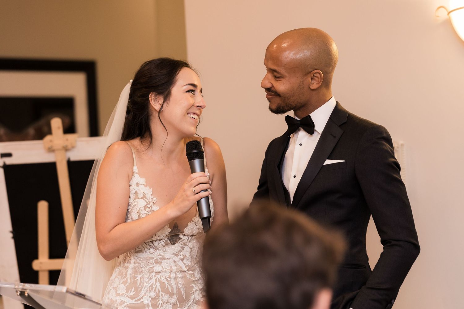 A joyous celebration moment at a wedding reception as a couple shares speeches with guests.