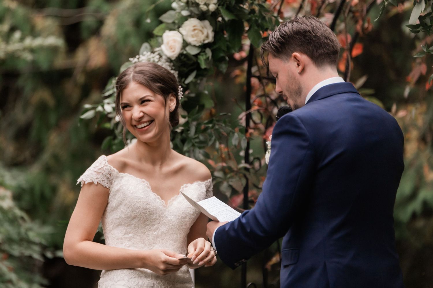 An intimate wedding ceremony moment showing vow exchanges under a lush garden setting.