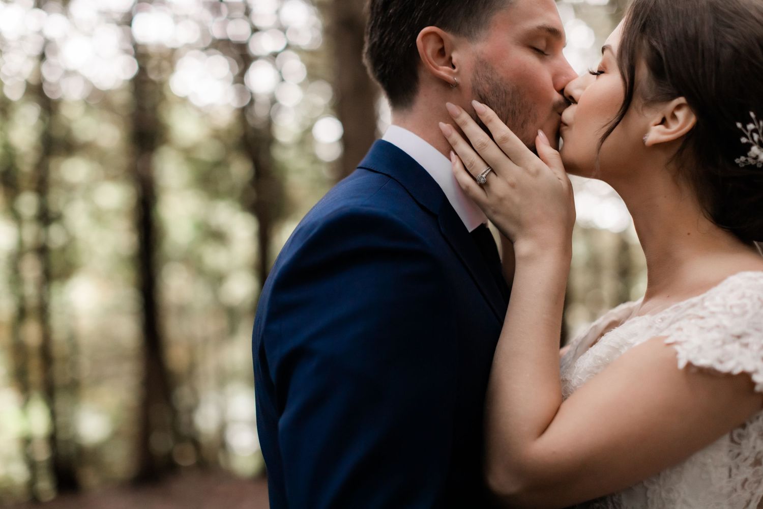 Intimate close-up of wedding couple sharing romantic moment in forest setting.