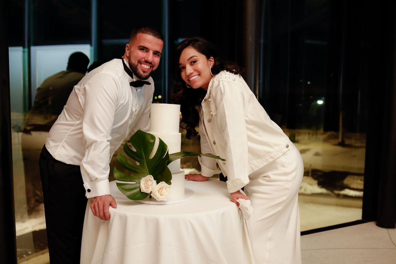 A couple poses playfully at their wedding reception table.